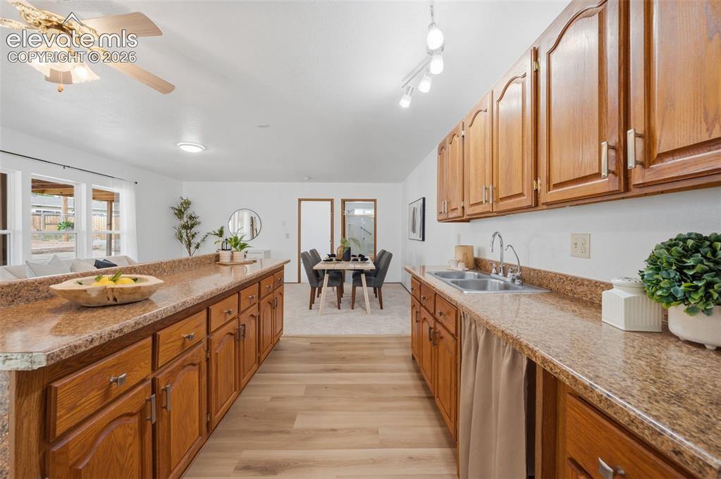 Image 28 of 38: Kitchen featuring wood-finish flooring, stone countertops, and wood cabinet