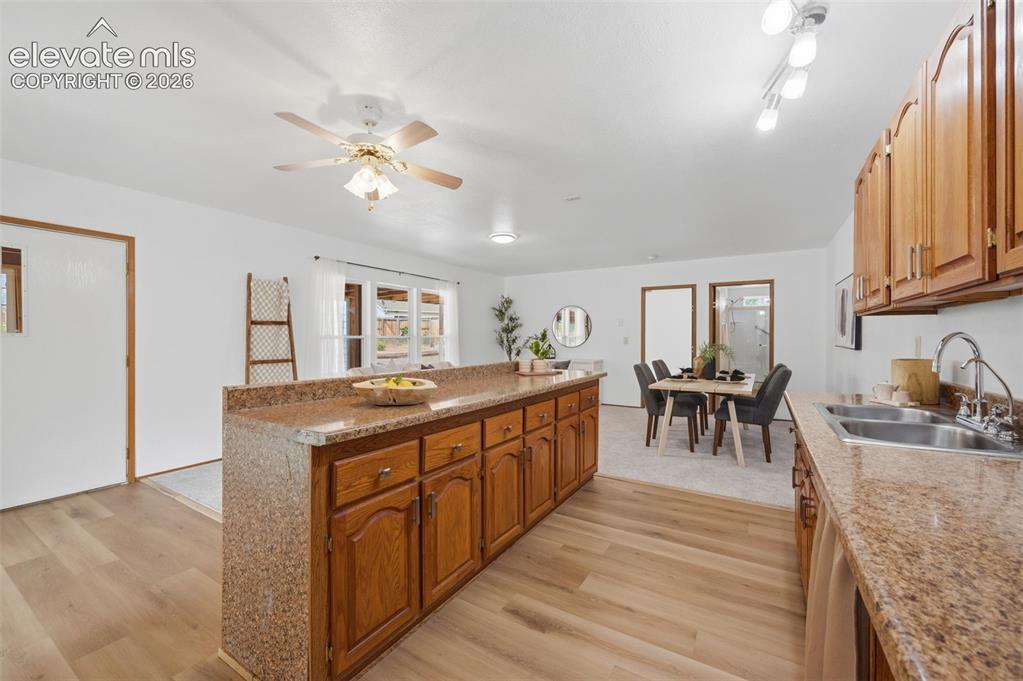 Image 29 of 38: Kitchen featuring wood cabinetry, a double basin stainless steel sink, trac