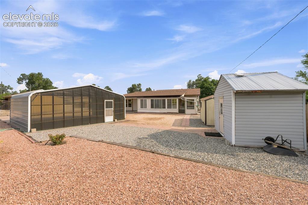 Image 35 of 38: Exterior featuring an extended covered patio, sunroom, and a red brick pave