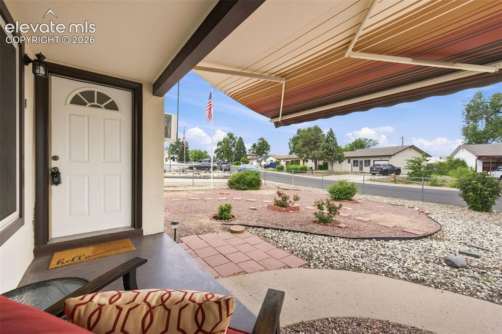 Image 4 of 38: Bright living area featuring wood-finish flooring, a ceiling fan with integ