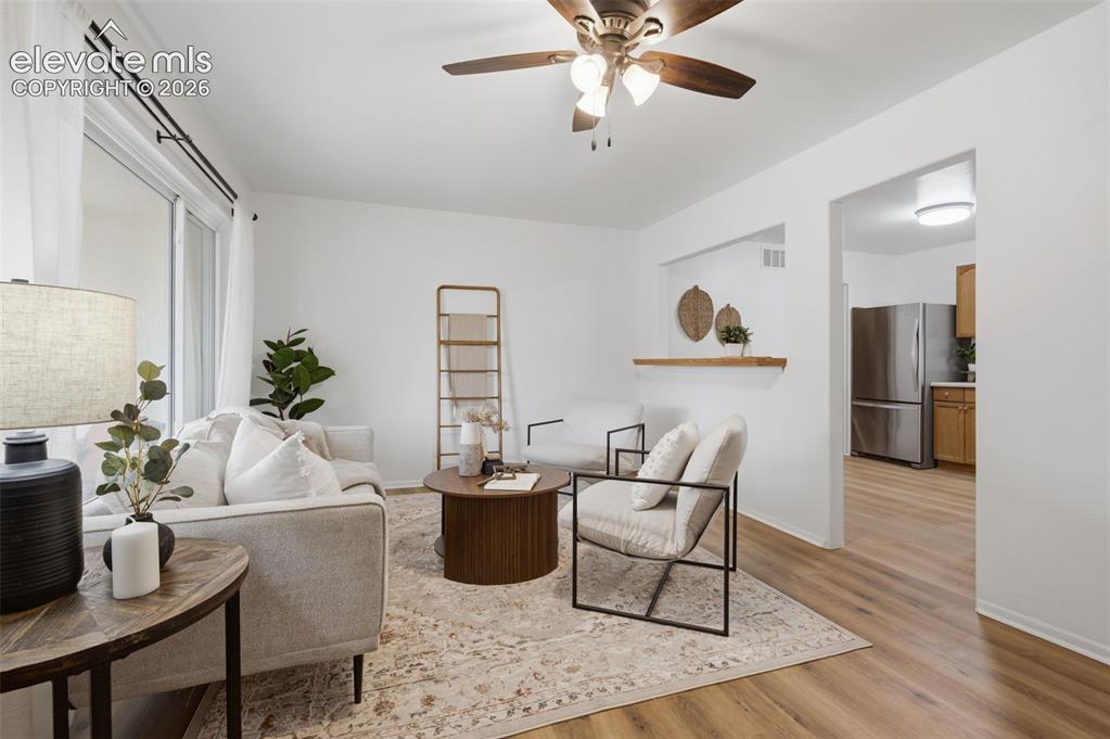 Image 5 of 38: Open-concept living area featuring wood-finish flooring, a contemporary cei