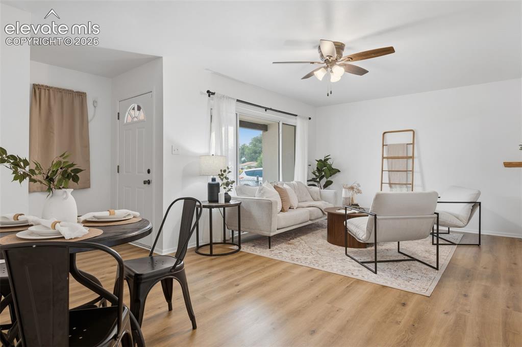 Image 6 of 38: Bright living space with wood-finish flooring and a ceiling fan with integr