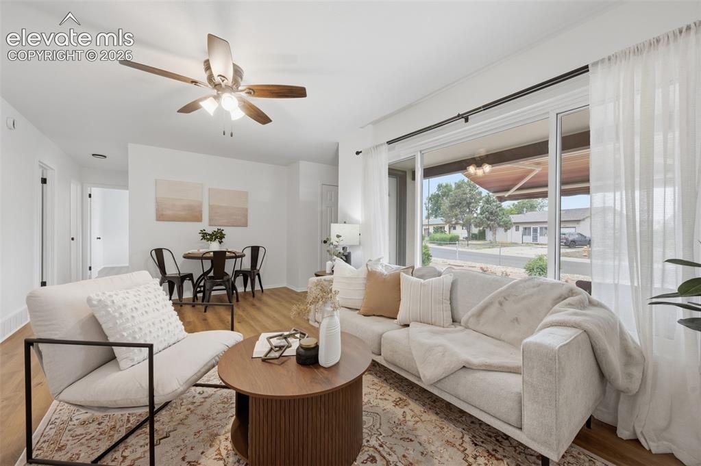 Image 9 of 38: Open-concept living space featuring wood-finish flooring, a contemporary ce
