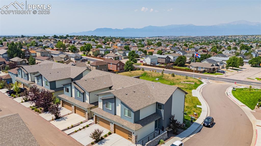 Image 31 of 33: Aerial view of residential area with a mountainous background