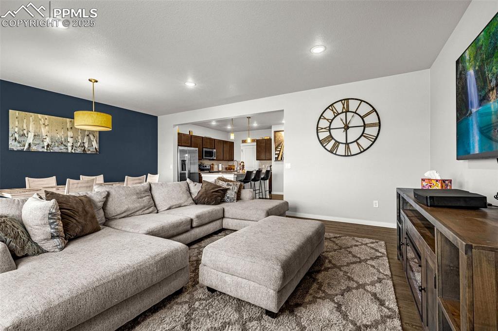 Image 8 of 33: Living room with dark wood-style flooring and recessed lighting
