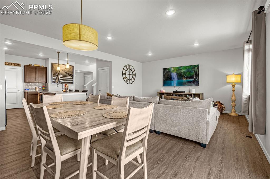 Image 9 of 33: Dining area featuring stairs, wood finished floors, and recessed lighting