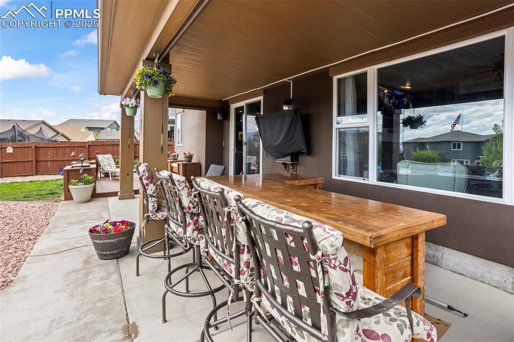 Image 17 of 45: View of patio with small bar.