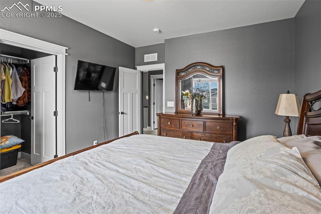 Image 35 of 45: 2nd Bedroom featuring a walk in closet and a textured wall