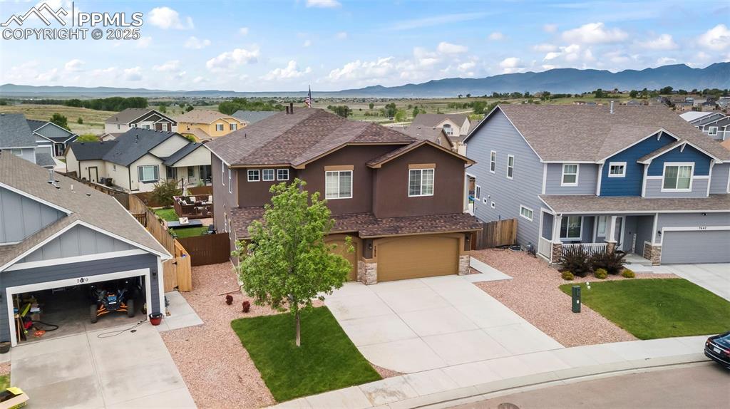 Image 4 of 45: View of front of property with a residential view, driveway, and stone sidi