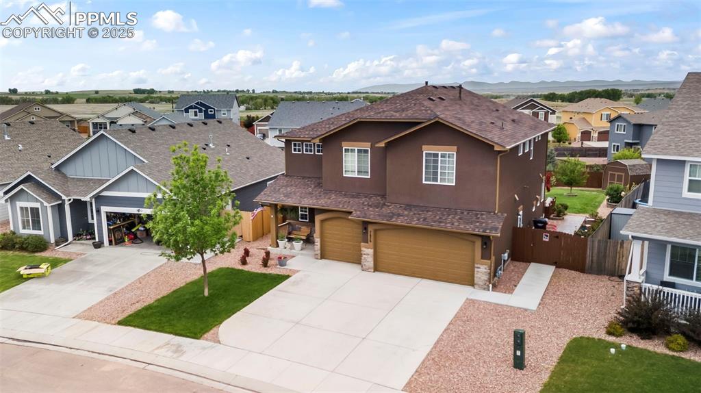 Image 5 of 45: Traditional-style home with stucco siding, a residential view, driveway, a 