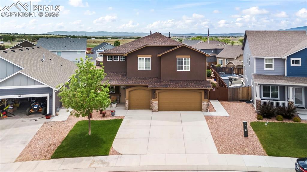 Image 6 of 45: Traditional home featuring stucco siding, driveway, a residential view, and