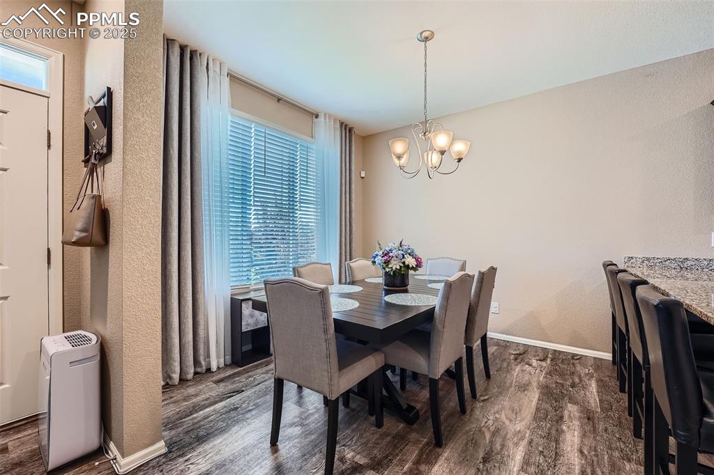 Image 10 of 32: Dining area with dark wood finished floors and a chandelier