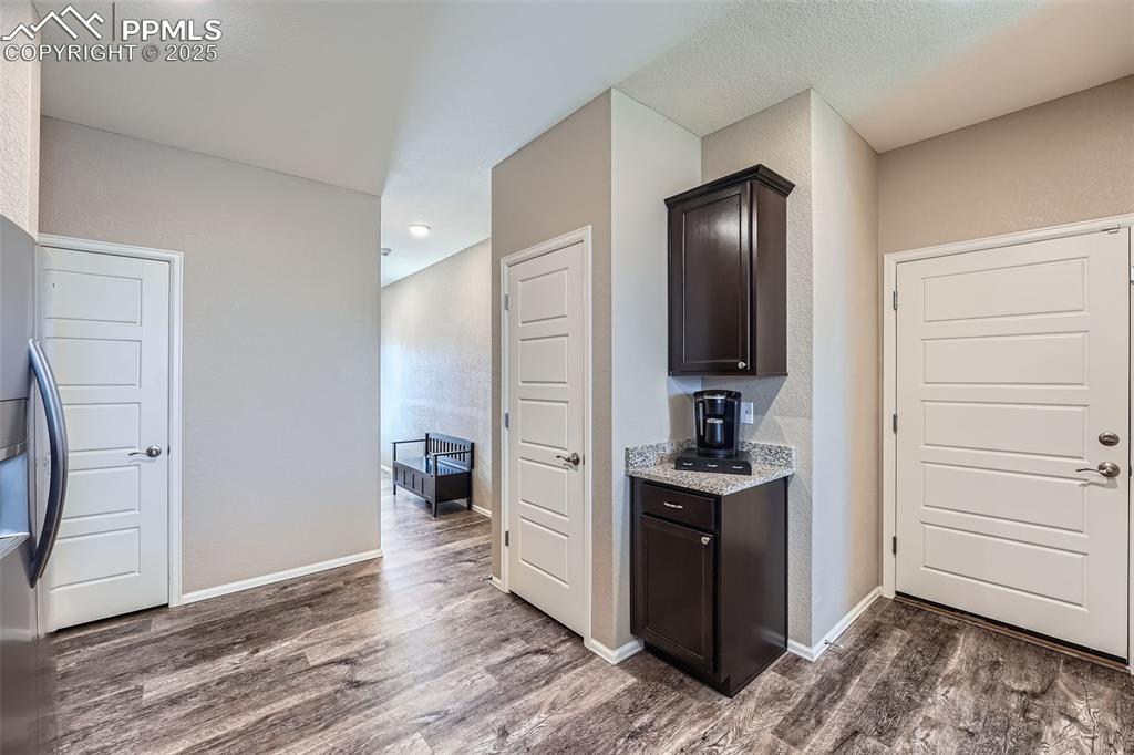 Image 13 of 32: Kitchen featuring dark wood-style floors, dark brown cabinets, and light st