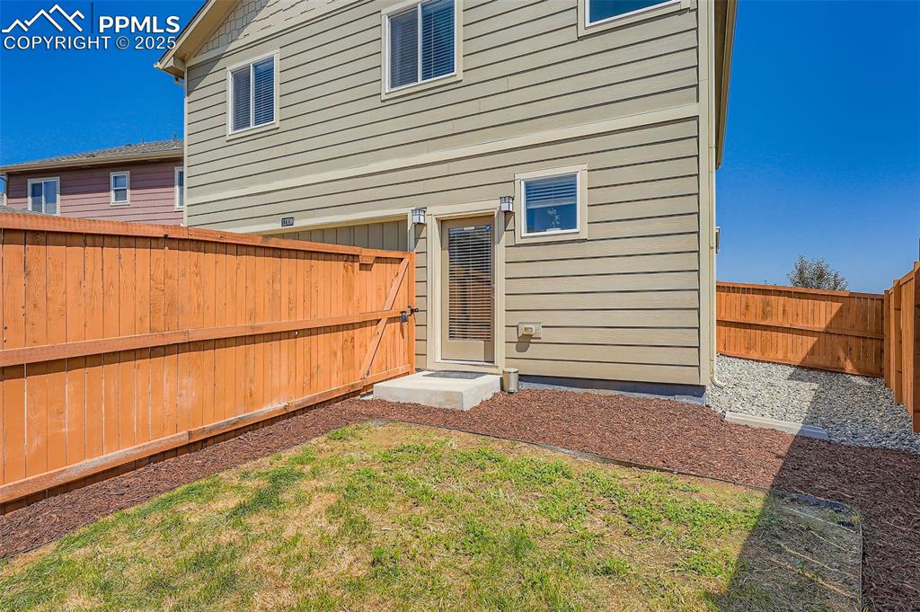 Image 27 of 32: Rear view of house featuring a fenced backyard