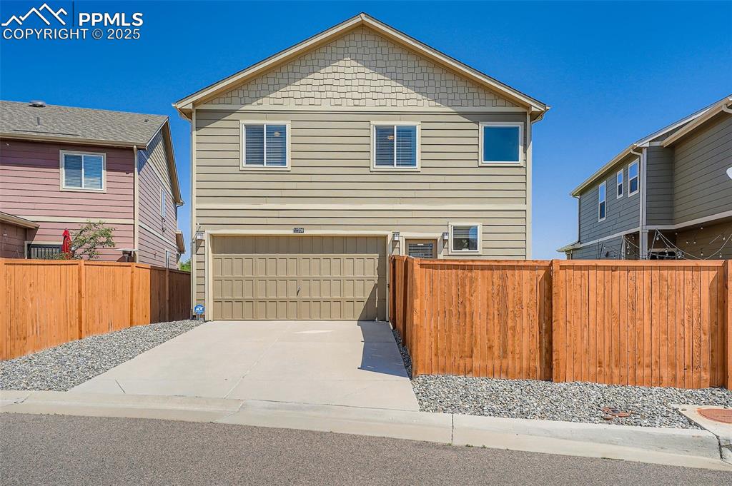 Image 29 of 32: View of back exterior featuring a garage and concrete driveway
