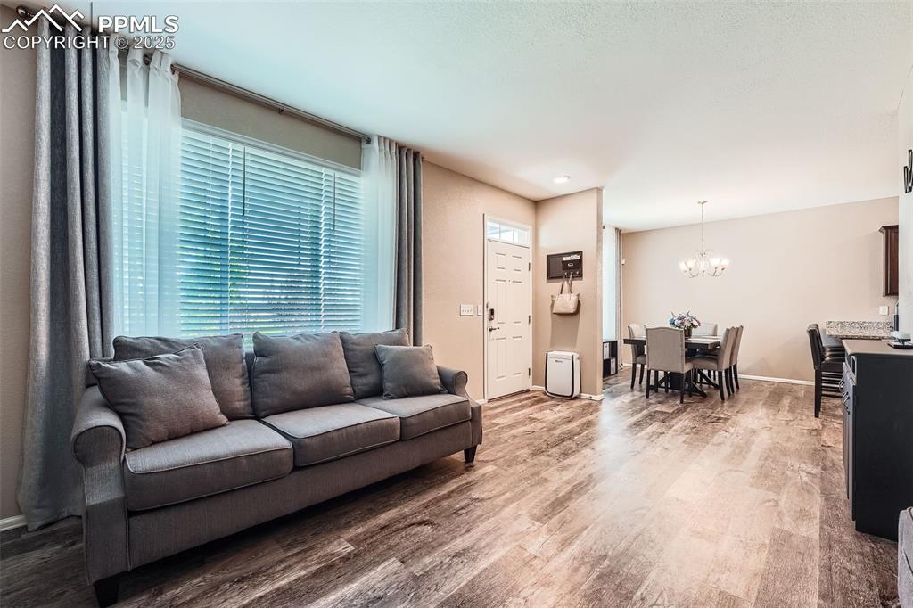 Image 6 of 32: Living room featuring a chandelier, wood finished floors, and plenty of nat