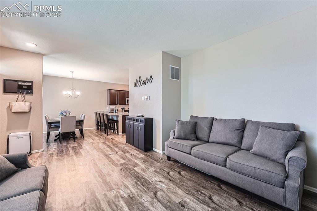 Image 9 of 32: Living area featuring light wood-type flooring and a chandelier