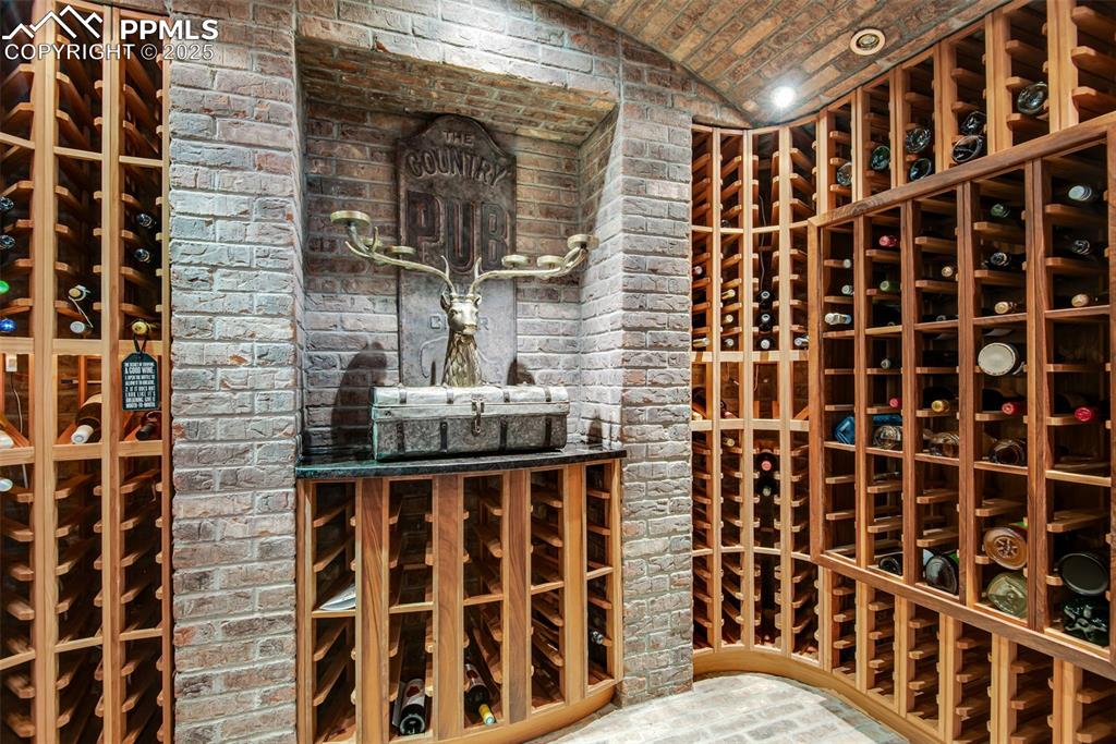 Image 20 of 38: A stone, walk-in wine cellar provides plenty of space for your collection.	