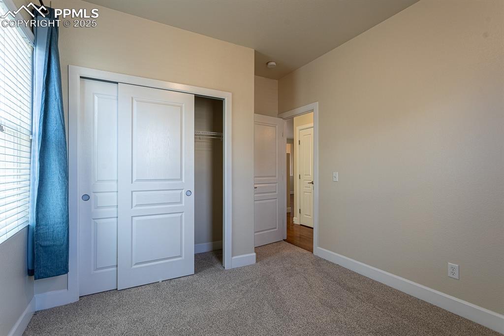Image 21 of 49: Unfurnished bedroom featuring a closet, carpet flooring, and baseboards