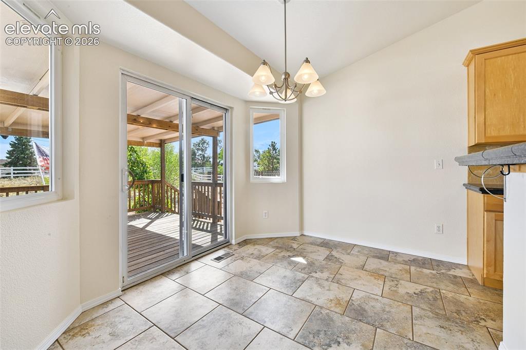 Image 11 of 50: Tiled flooring and a ceiling-mounted light fixture illuminate this bright s