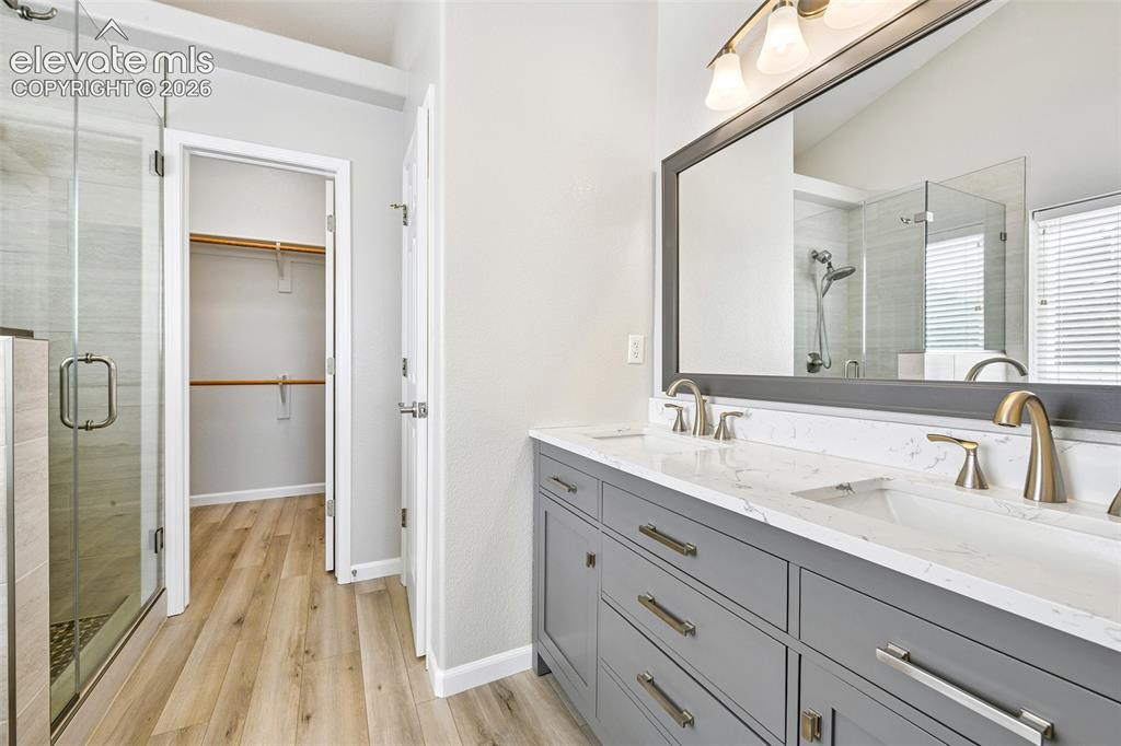 Image 18 of 50: Dual vanity with quartz-finish countertop and undermount sinks, wood-finish