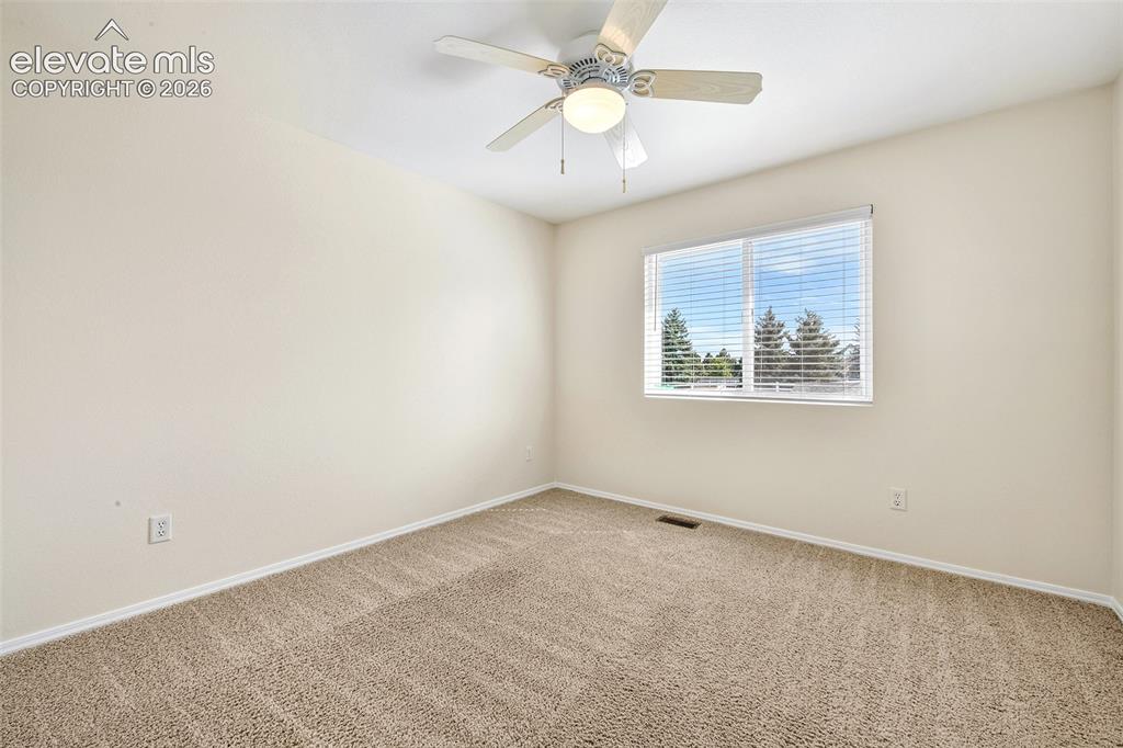 Image 24 of 50: Light-colored walls, broadloom carpeting, ceiling fan with integrated light