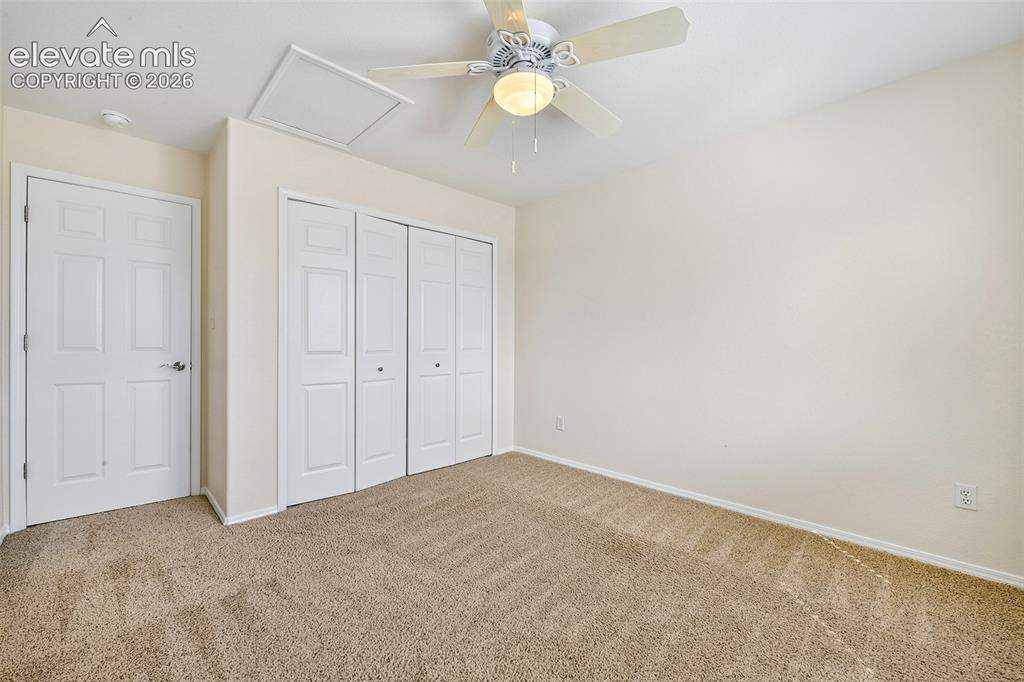 Image 25 of 50: Neutral wall tones, ceiling fan with integrated lighting, textured carpetin