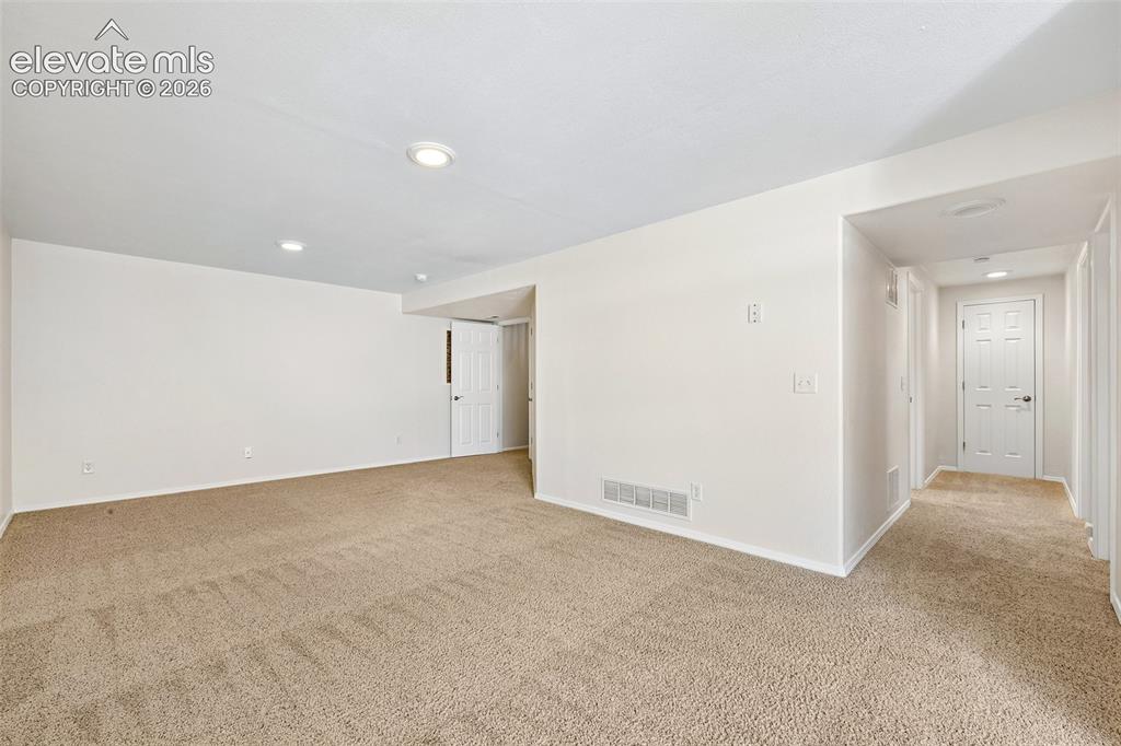 Image 28 of 50: Basement Family Room , Recessed ceiling lighting, neutral tone carpet floor