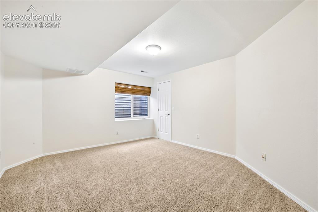Image 29 of 50: Basement bedroom, Carpeted room with white walls, a single window, recessed