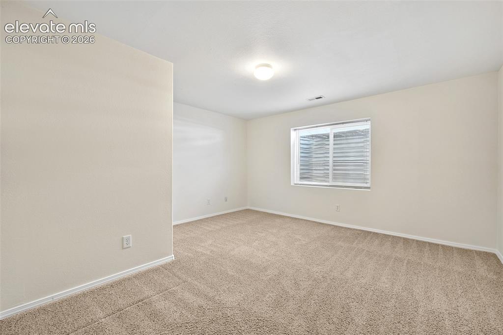 Image 30 of 50: Basement Bedroom, Neutral tone wall paint, flush mount ceiling light, carpe