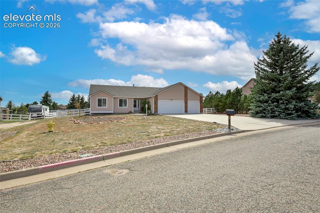Image 33 of 50: Ranch-style residence featuring a three-car garage, concrete driveway, and