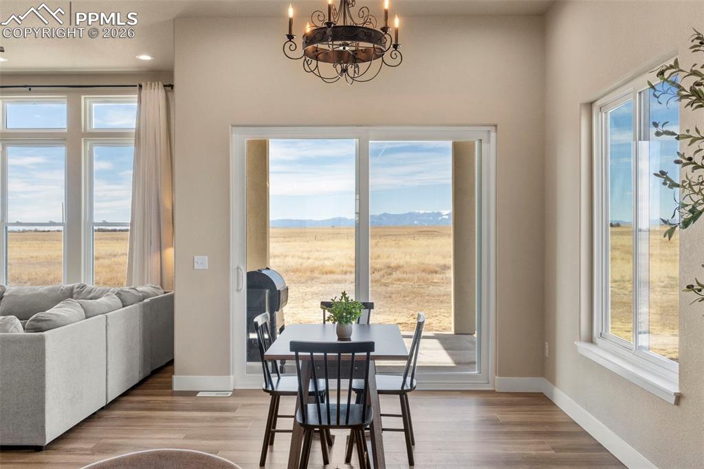 Image 10 of 50: Dining area with custom lighting walks out to covered patio