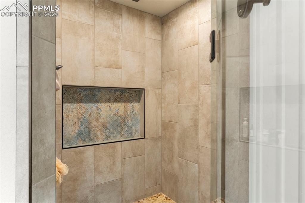 Image 21 of 50: Tile shower with bench and glass door