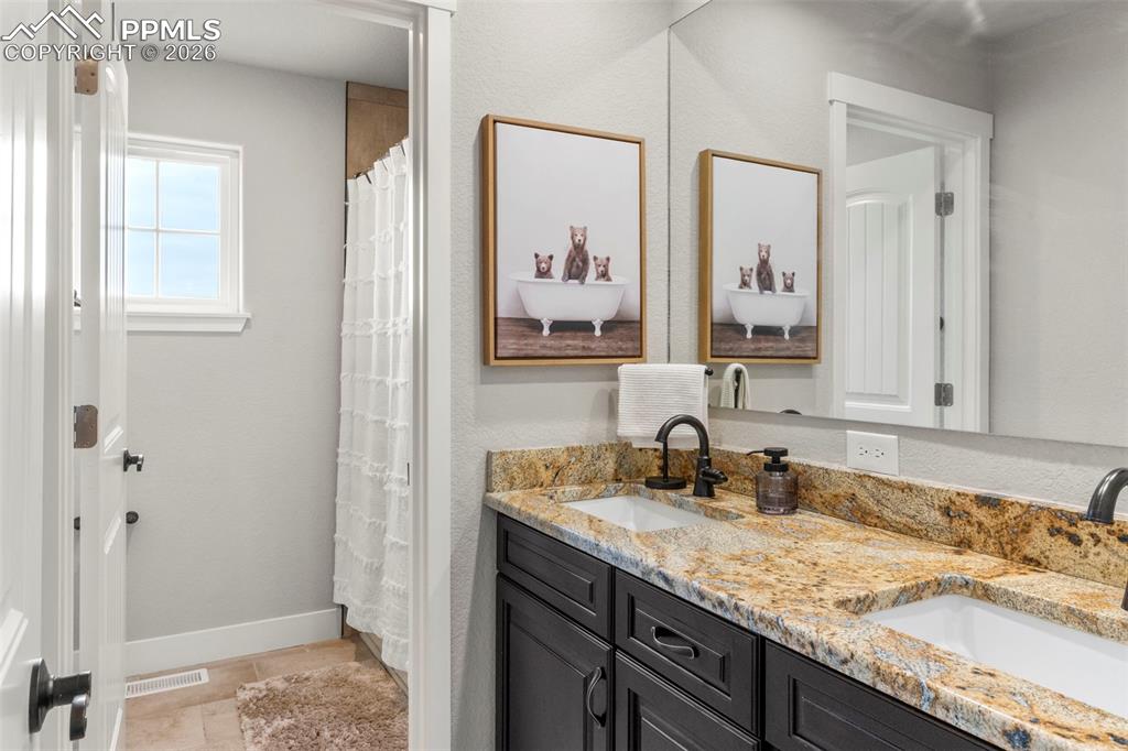 Image 23 of 50: Double sink granite vanities in both primary baths