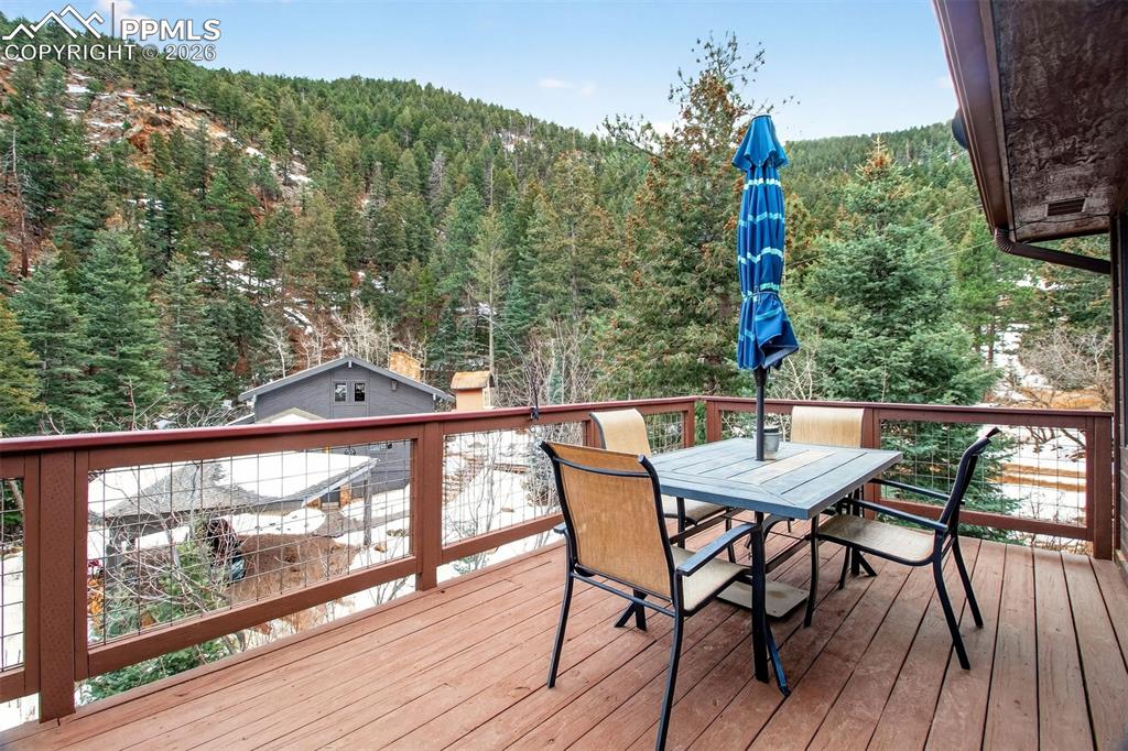 Image 11 of 43: Main level wrap around deck. Just look at the surrounding views!!!