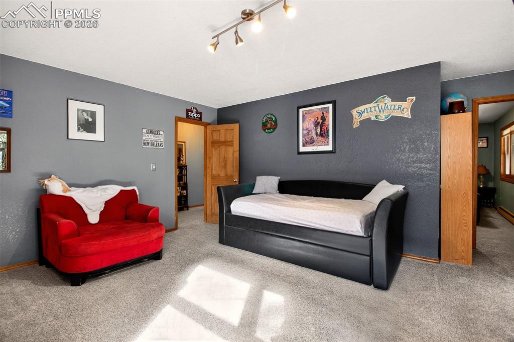 Image 31 of 43: Family room with walk out to covered lower deck with hot tub and dog run