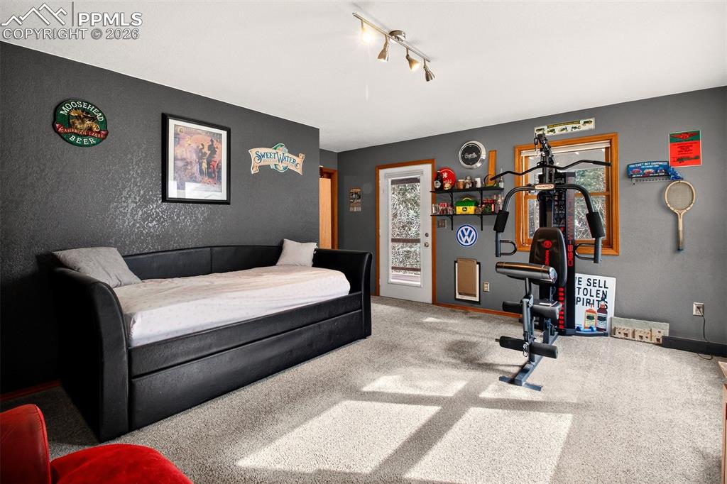 Image 32 of 43: Family room with walk out to covered lower deck with hot tub and dog run