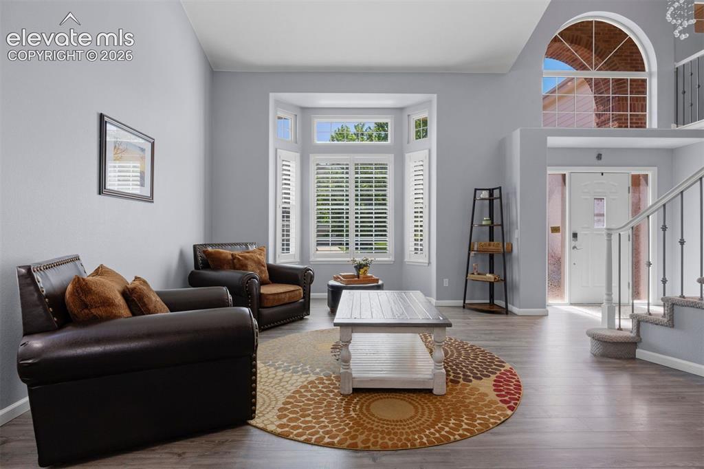 Image 11 of 50: Living area featuring vinyl flooring, a bay window with plantation shutters