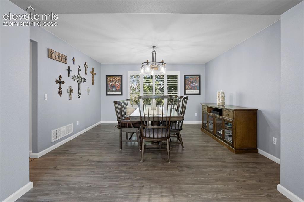 Image 17 of 50: Spacious room featuring vinyl flooring, a contemporary chandelier, and wind