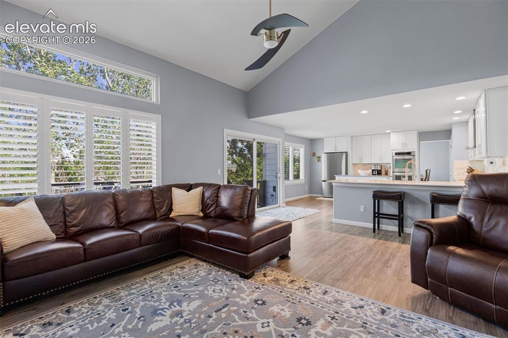 Image 20 of 50: Open-concept living space featuring wood-finish flooring and a vaulted ceil