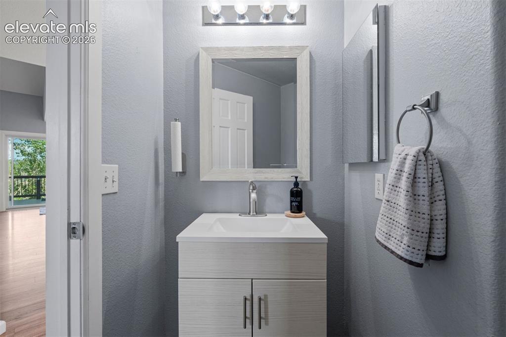 Image 24 of 50: Bathroom vanity featuring a white rectangular sink, chrome faucet, and inte
