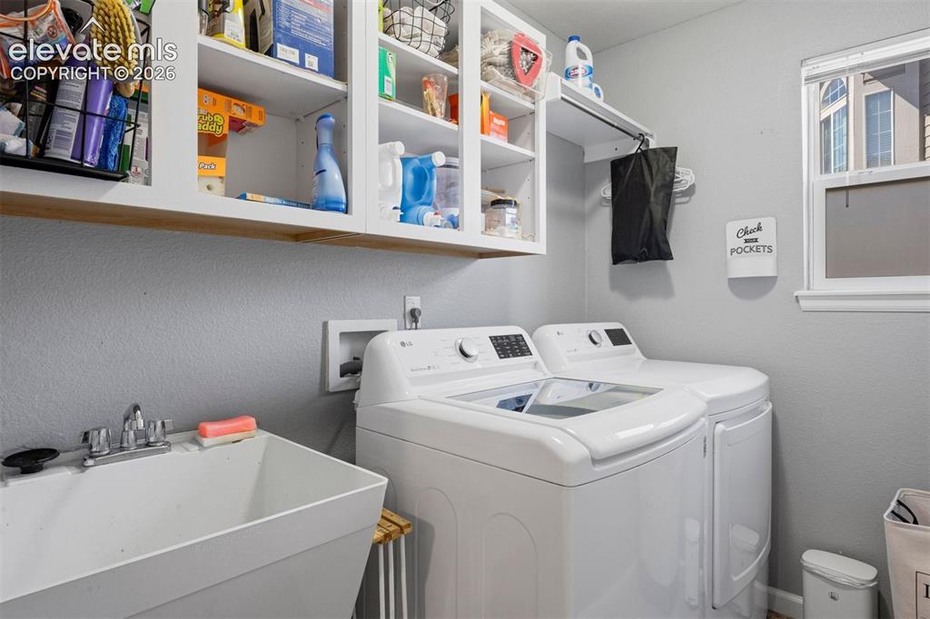 Image 25 of 50: Dedicated laundry area featuring a utility sink with a chrome faucet, overh
