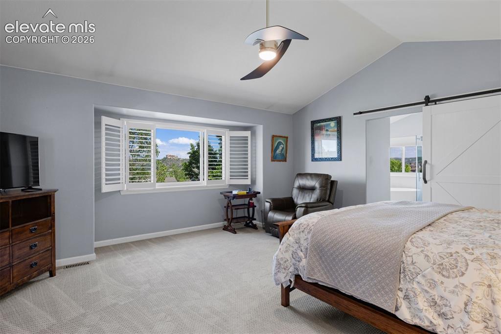 Image 27 of 50: Spacious room featuring a vaulted ceiling with a modern ceiling fan, a larg