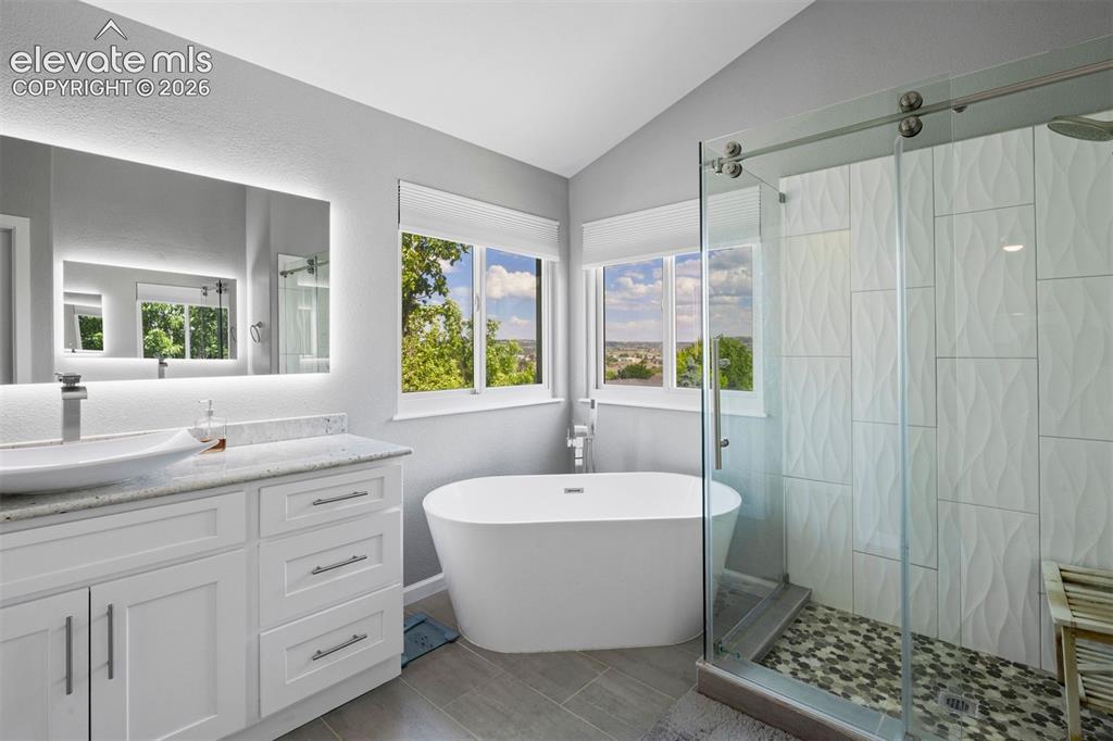 Image 29 of 50: Modern bathroom featuring a freestanding soaking tub, a frameless glass-enc