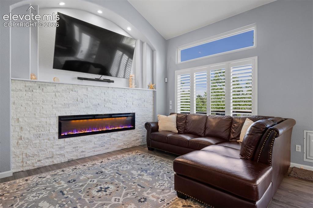 Image 3 of 50: Living area featuring a textured stone-finish fireplace with an integrated