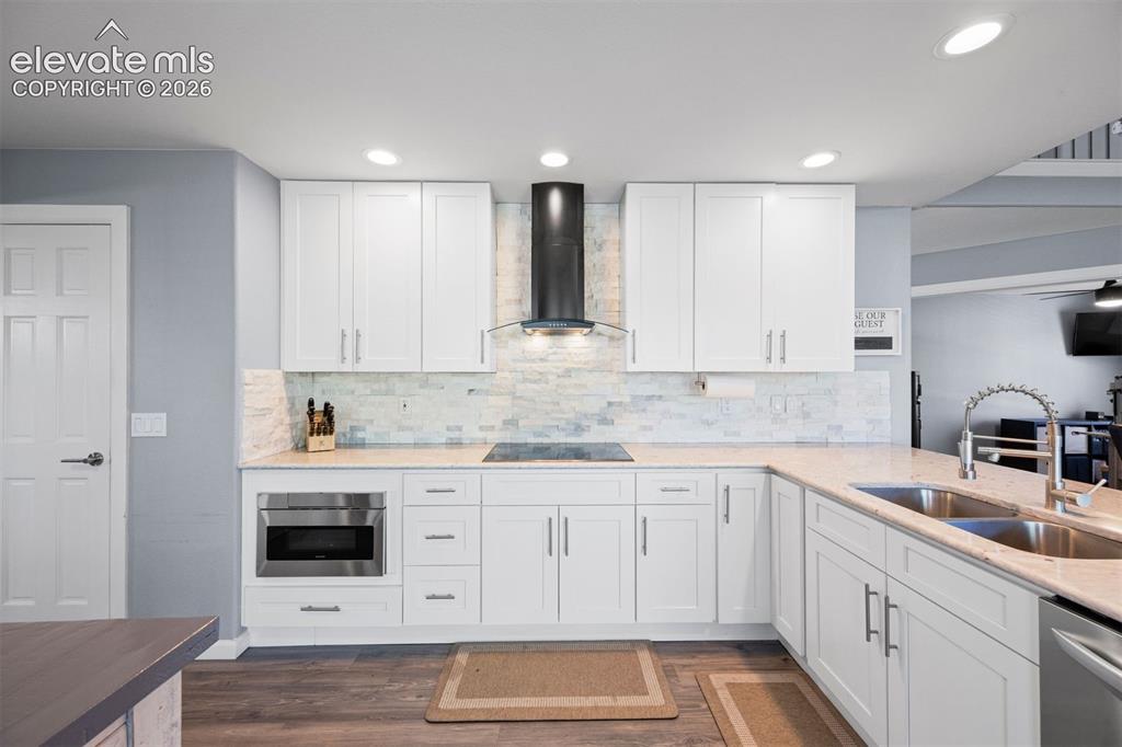 Image 4 of 50: Contemporary kitchen featuring white cabinetry, light-toned countertops, an
