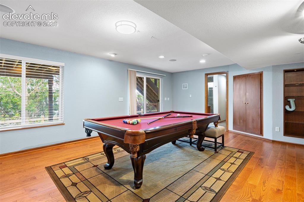 Image 40 of 50: Entertainment room featuring wood-finish flooring, recessed lighting, and a