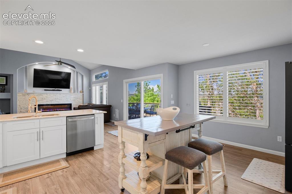 Image 5 of 50: Open-concept kitchen and living area featuring eat-in kitchen space, white