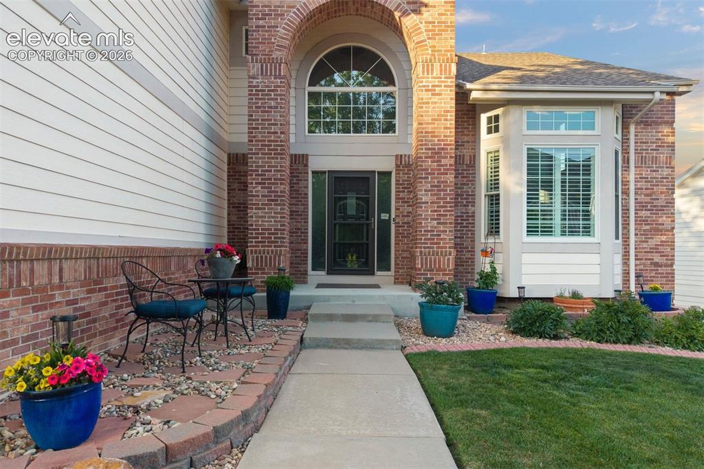 Image 8 of 50: Brick and siding exterior featuring an arched entry with transom window