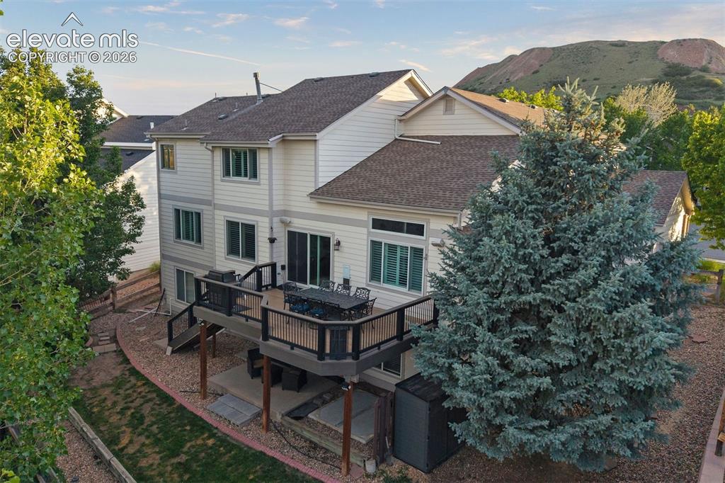 Image 9 of 50: Rear exterior featuring a composite deck with black railings, a walk-out co